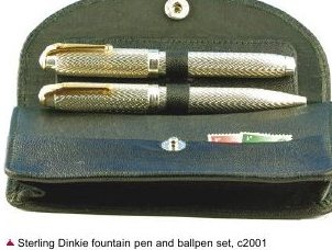 A slim silver fountain pen and matching ballpen with fine engine-turned barrels and gold-coloured clips, resting in a dark green leather case.