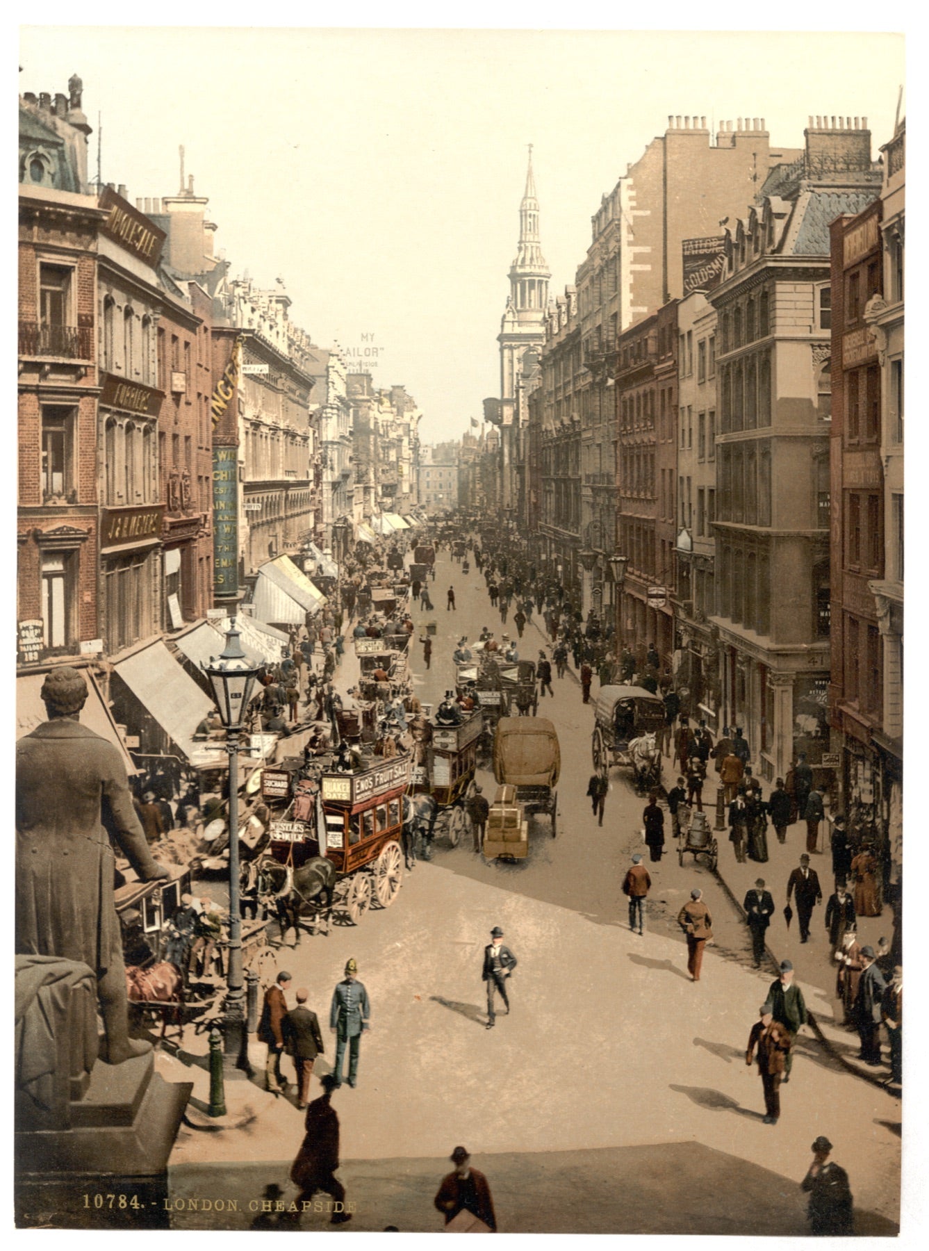 A colour photochrom print of Cheapside in the City of London around 1900: horse-drawn omnibuses, awnings over shopfronts and crowds on the pavement